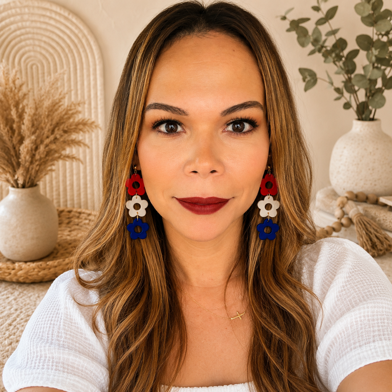 Woman wearing colorful earrings with a neutral background