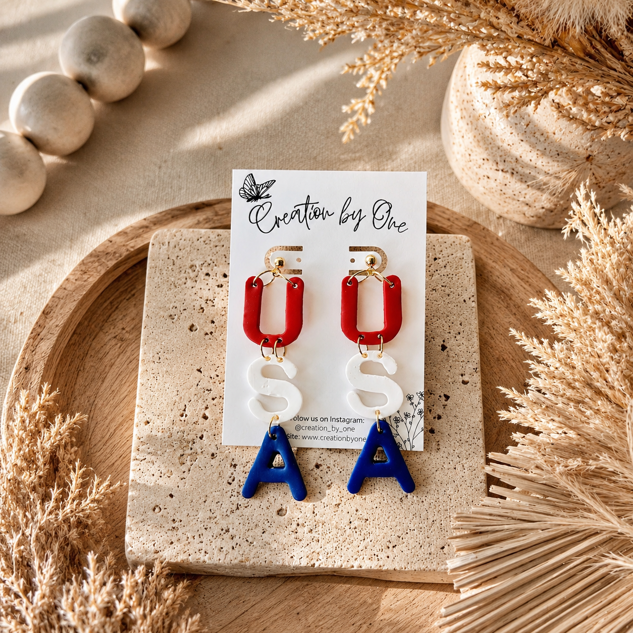 Pair of earrings on a display card with decorative elements on a wooden surface