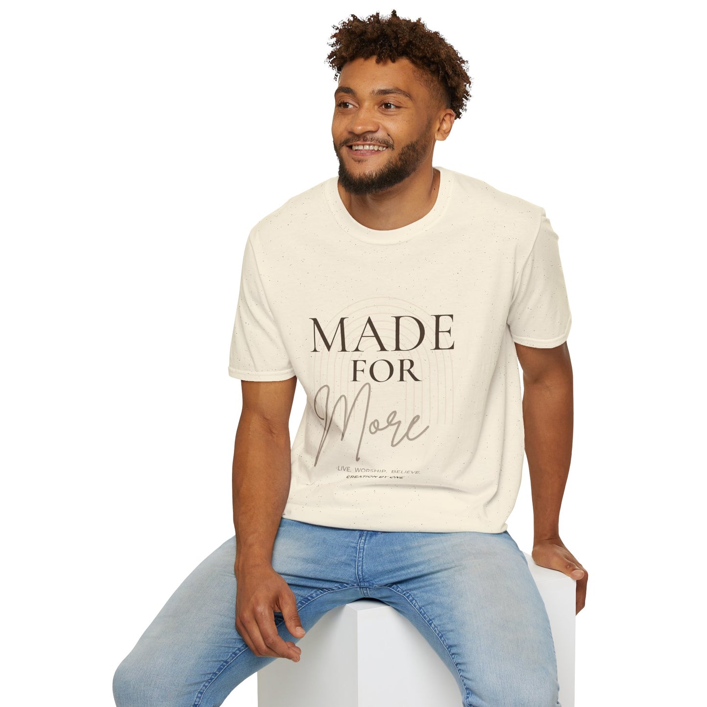 Man wearing a cream t-shirt with a rocket design and text, sitting on a white stool against a white background.