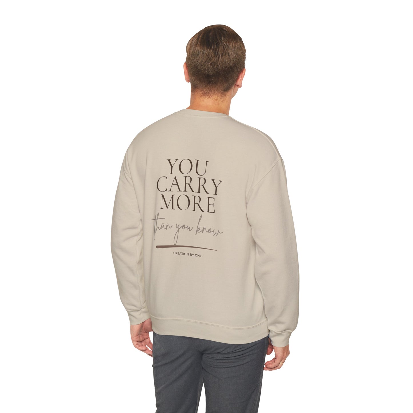 Man wearing a beige sweatshirt with a floral design on the back, standing against a white background