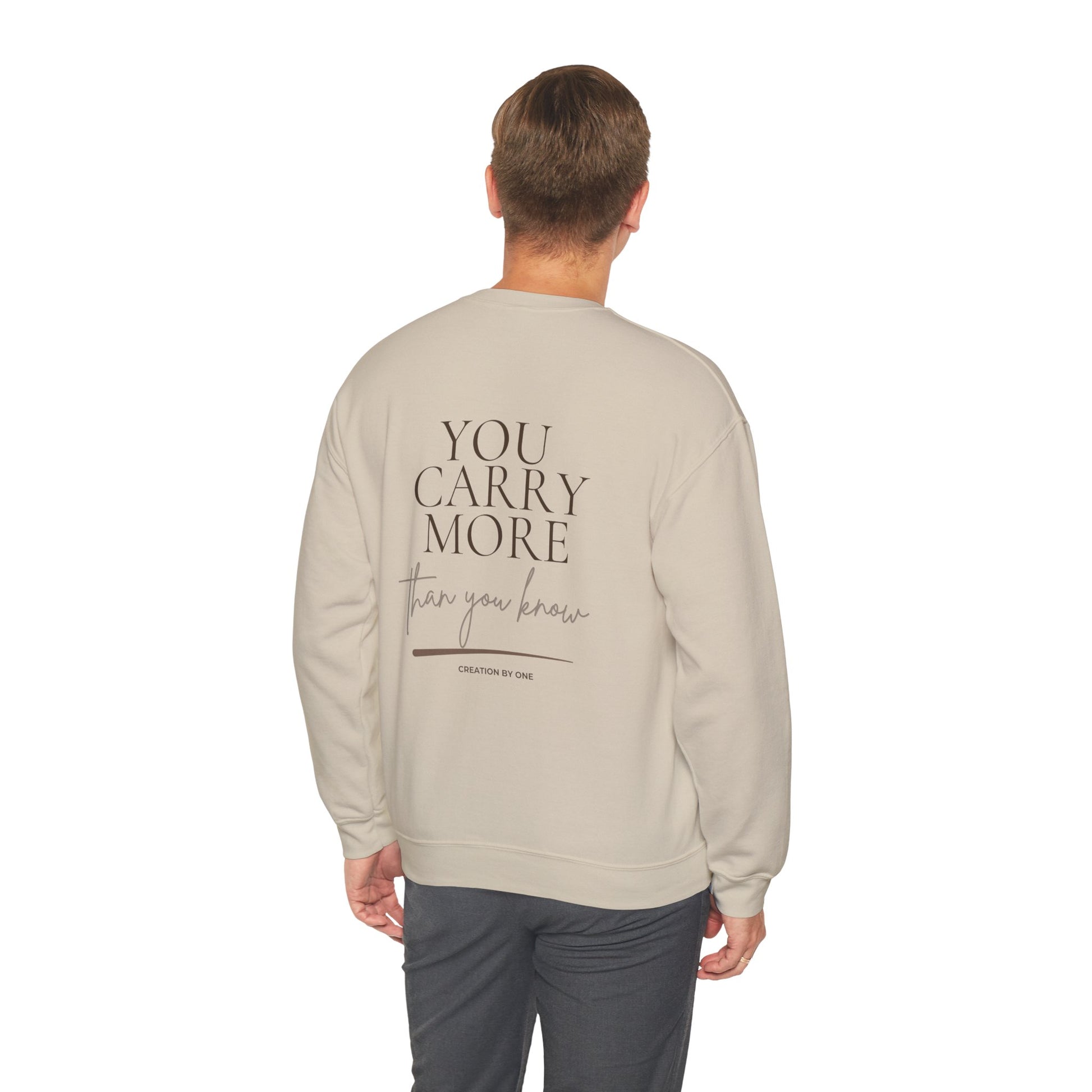 Man wearing a beige sweatshirt with a floral design on the back, standing against a white background