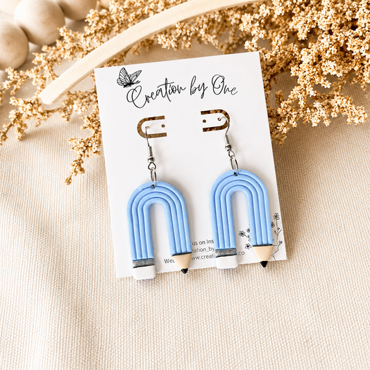 Blue U-shaped earrings on a 'Creation by One' branded card with decorative elements.