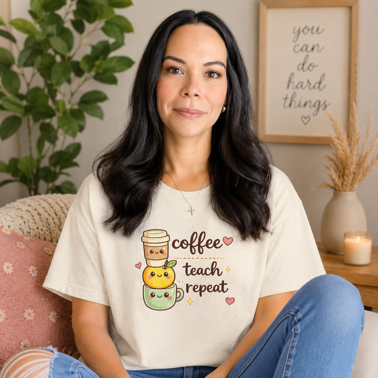 Woman wearing a t-shirt with coffee-themed design sitting in a cozy room.