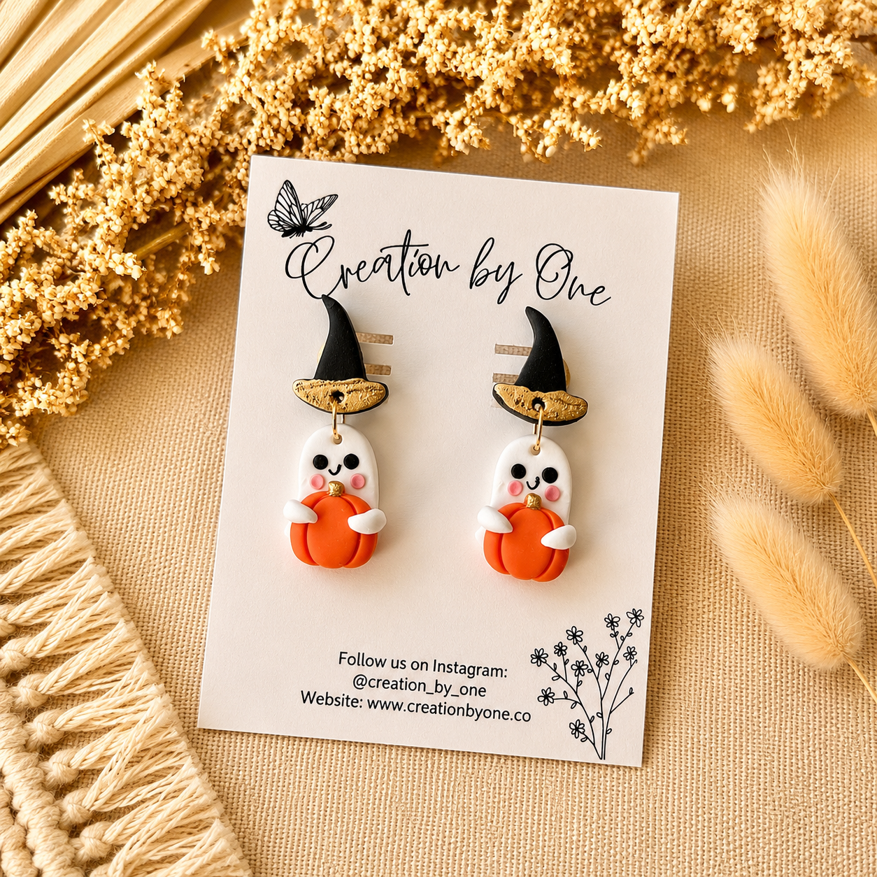 Halloween-themed earrings on a card with decorative elements
