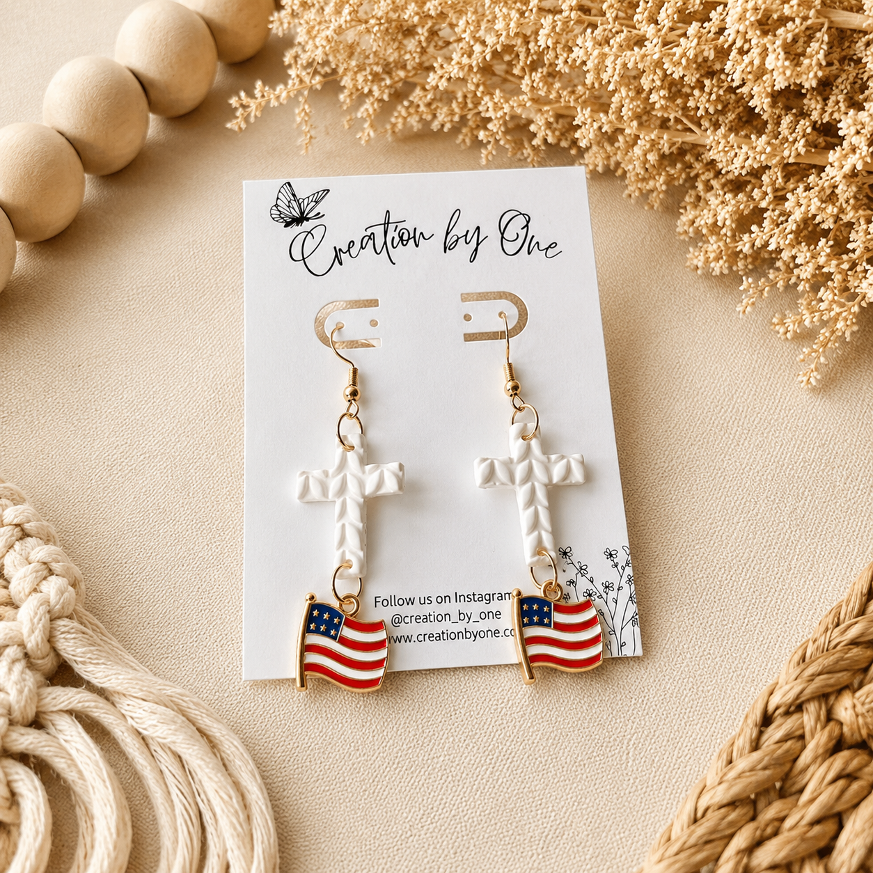 Earrings with American flag design on a branded card with decorative elements.