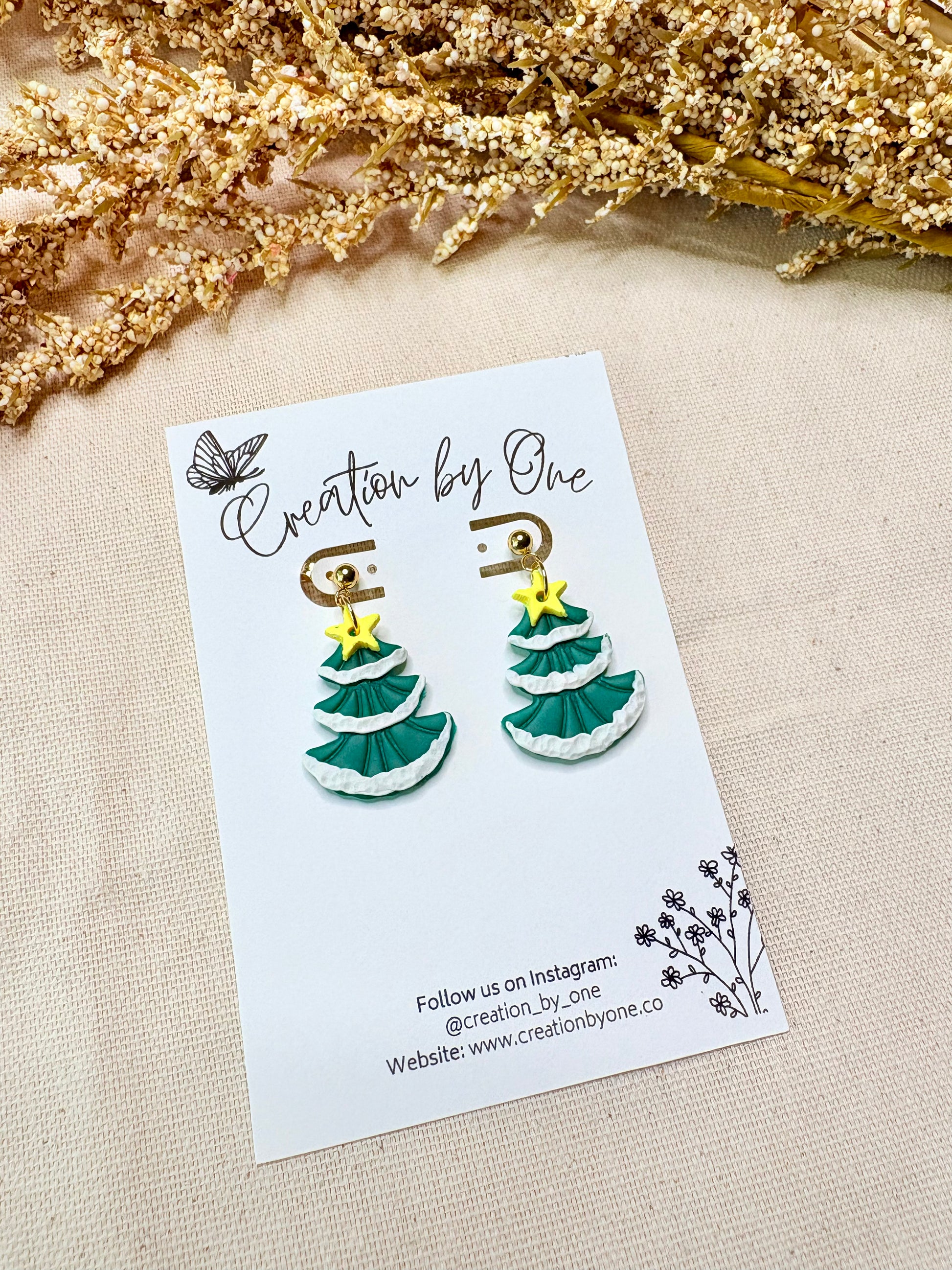 Festive snowy Christmas tree stud earrings with golden star, crafted from polymer clay