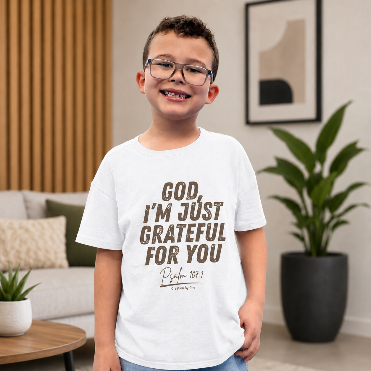 Child wearing a white t-shirt with text in a living room setting