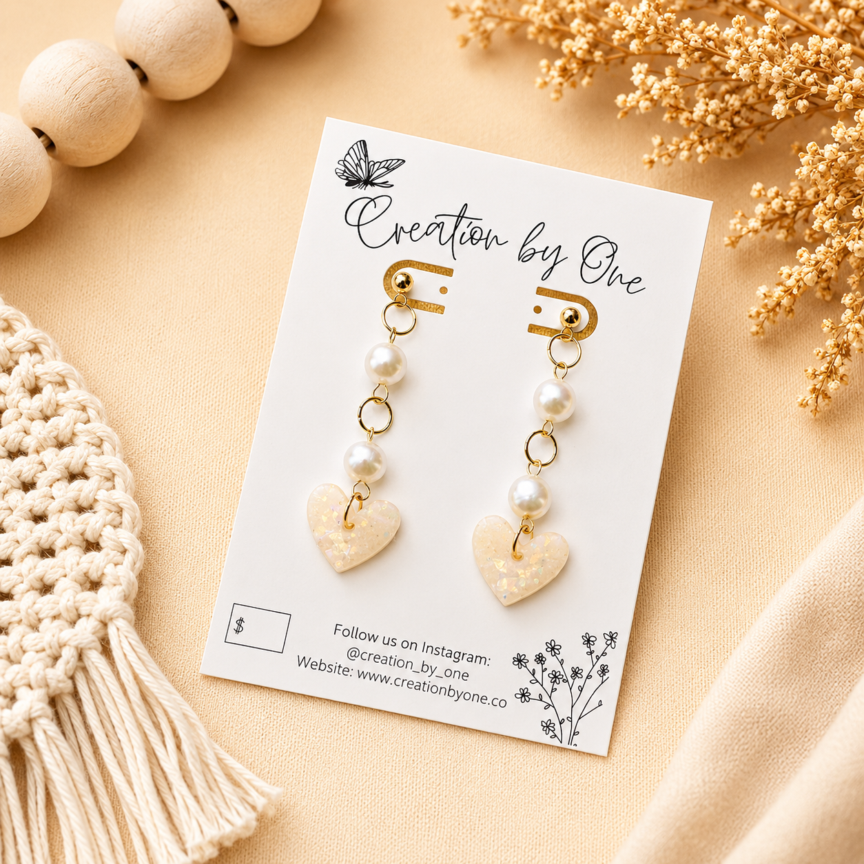 Handmade pearl and iridescent heart polymer clay dangle earrings with gold-plated studs on a neutral boho background
