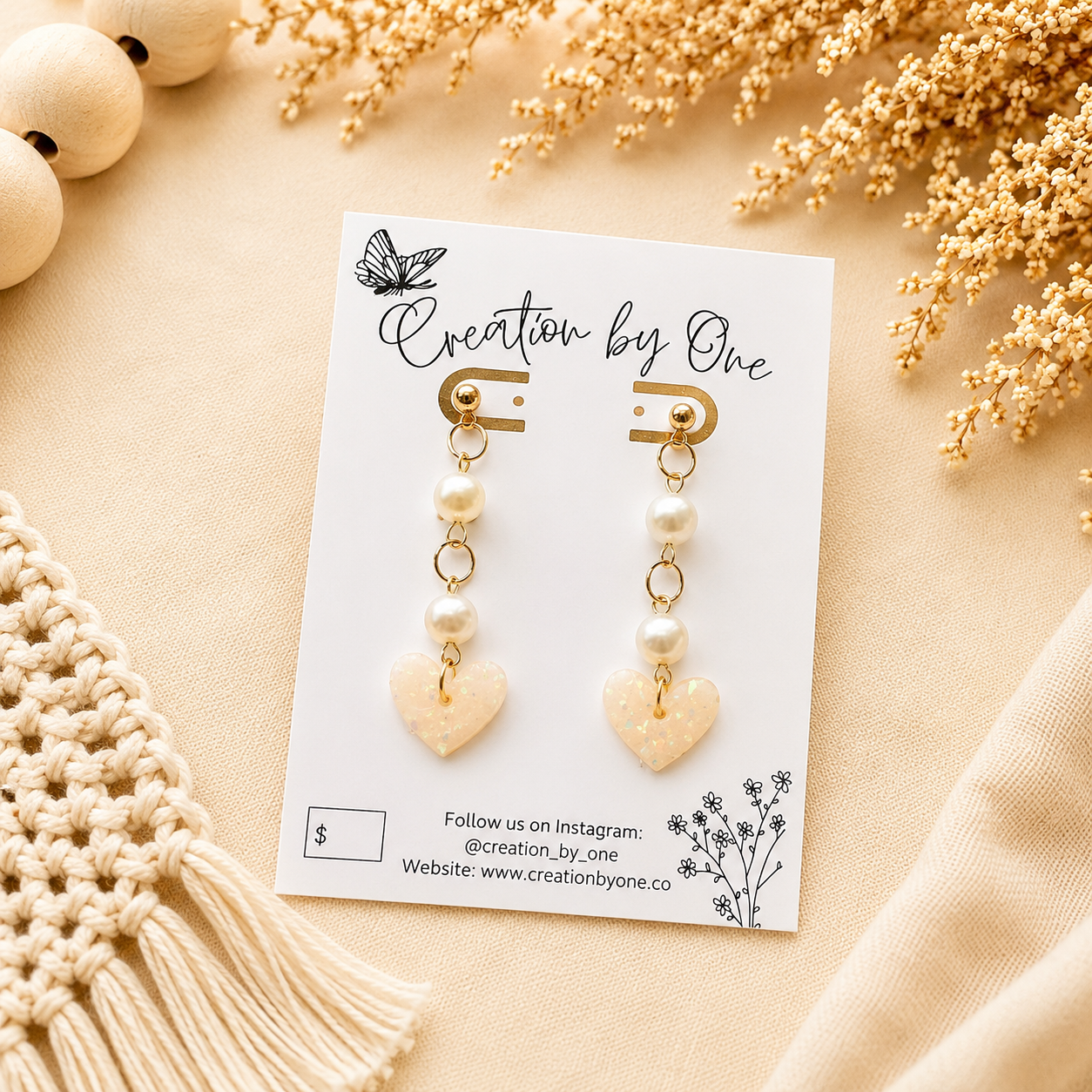 Handmade pearl and iridescent heart polymer clay dangle earrings with gold-plated studs on a neutral boho background