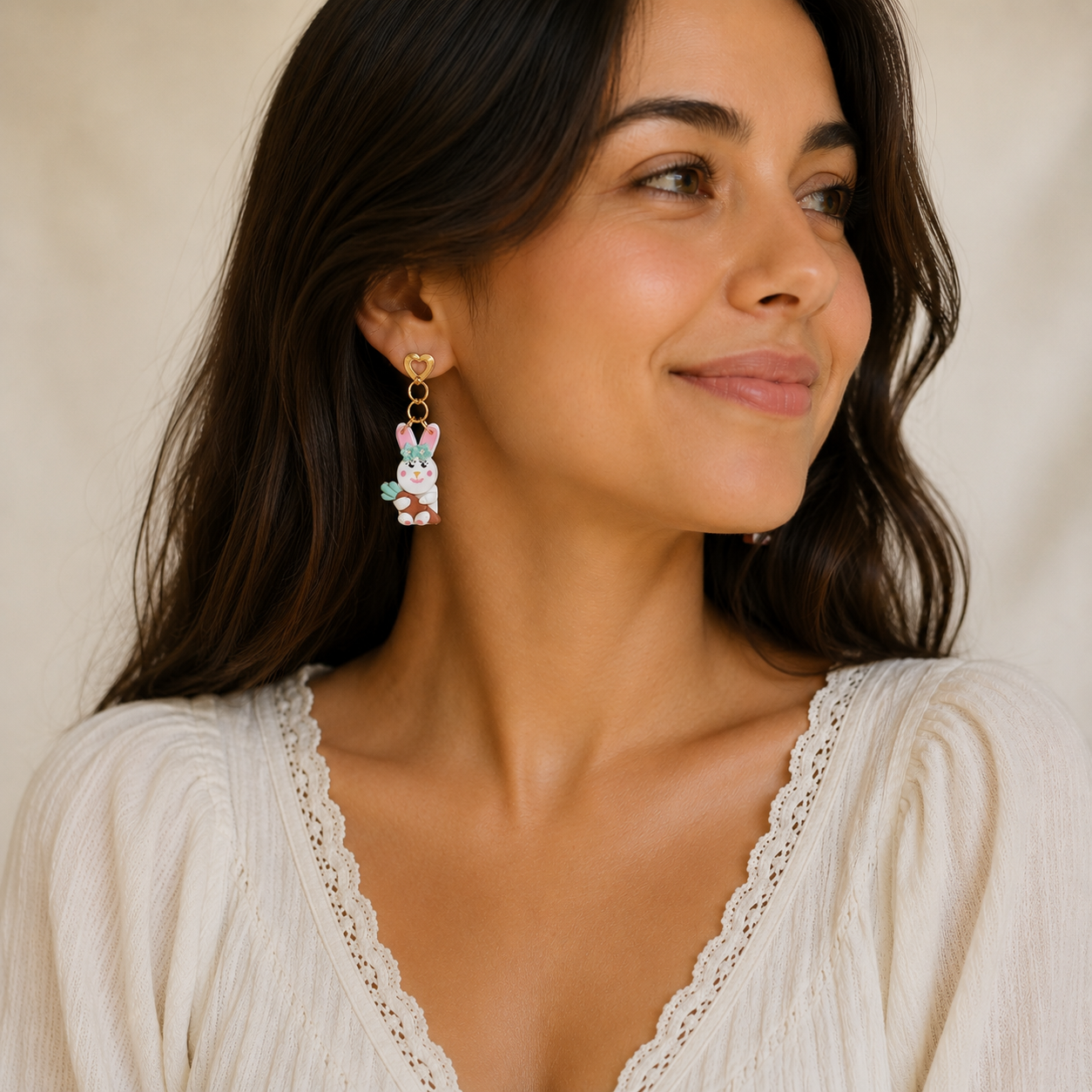 Woman wearing bunny-shaped earrings with a neutral background