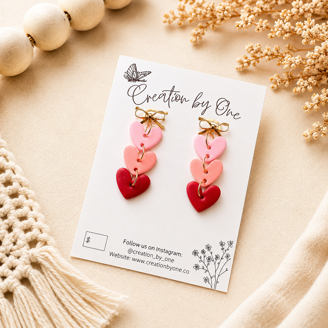     Handmade pink layered heart dangle earrings with gold bow studs on a neutral boho background