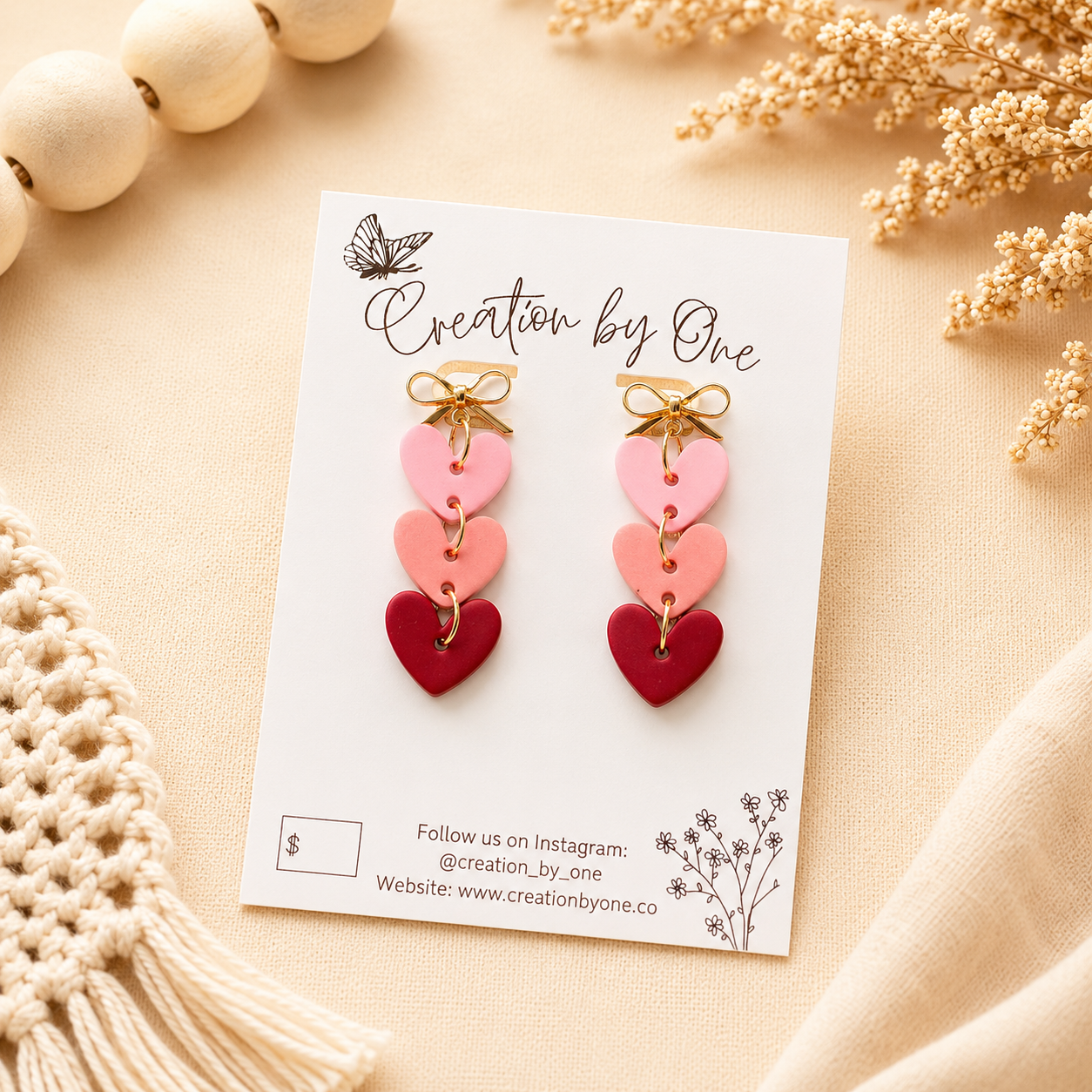     Handmade pink layered heart dangle earrings with gold bow studs on a neutral boho background