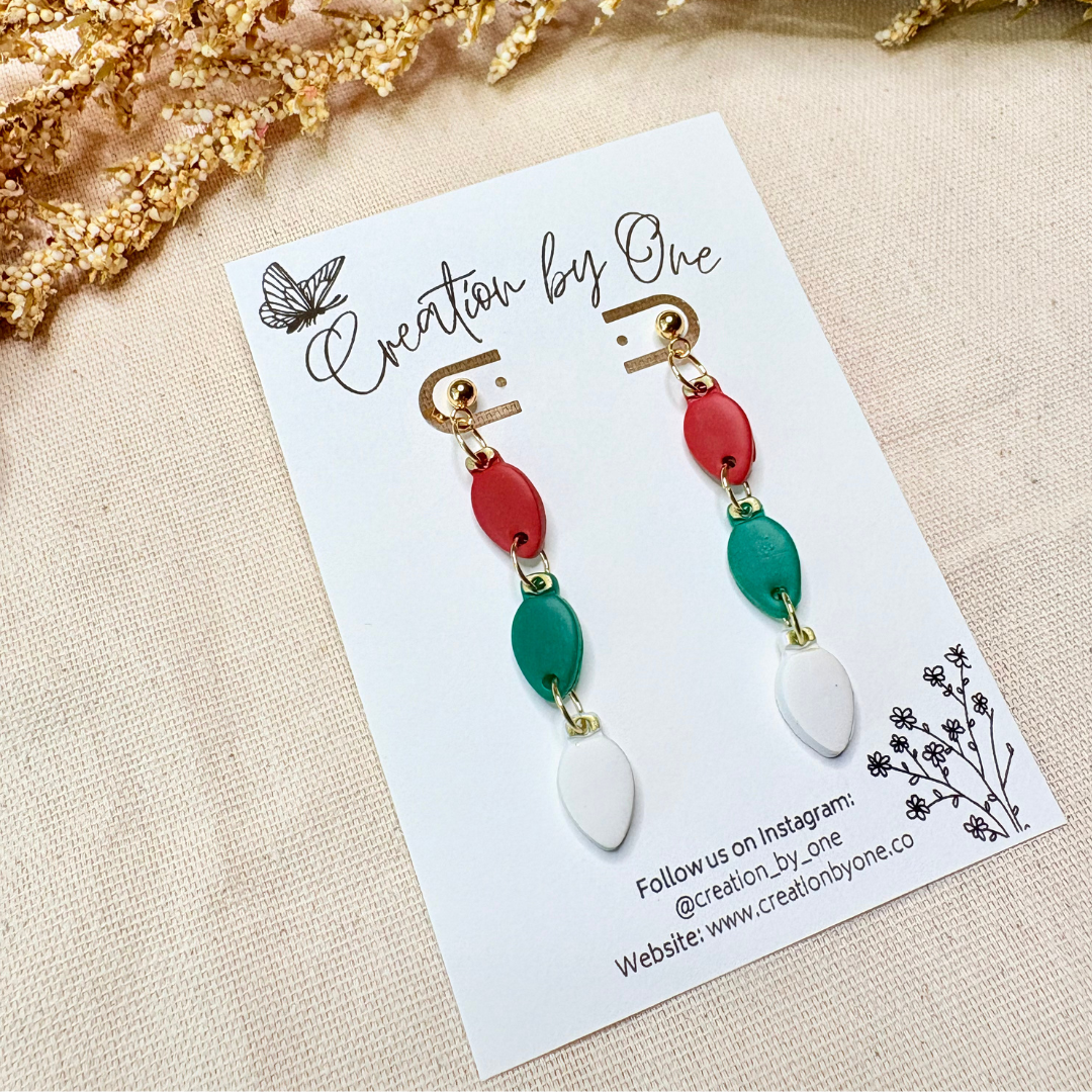 Handmade polymer clay Christmas light bulb stud earrings in red, green, and white with 14K gold-plated posts
