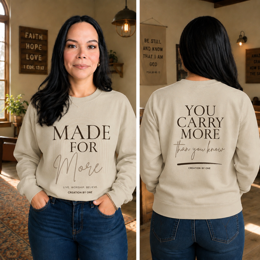 Woman wearing a beige sweatshirt with text on the front and back, standing in a room with decor.