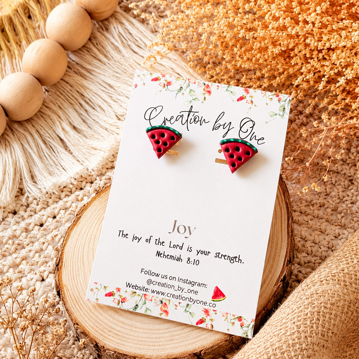 Watermelon slice earrings on a 'Creation by One' branded card with decorative elements.