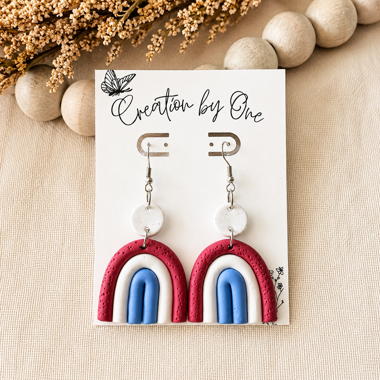 Land of Grace Arches handmade clay earrings by Creation By One featuring dusty blue, cream, and berry arch design. Lightweight Christian statement earrings for women.