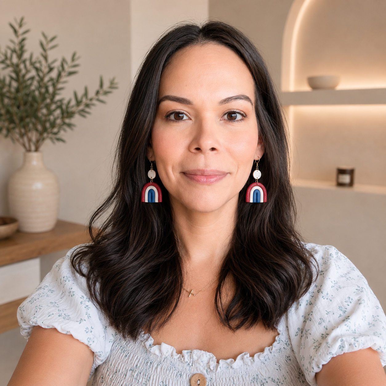 Woman wearing colorful rainbow earrings in a home setting