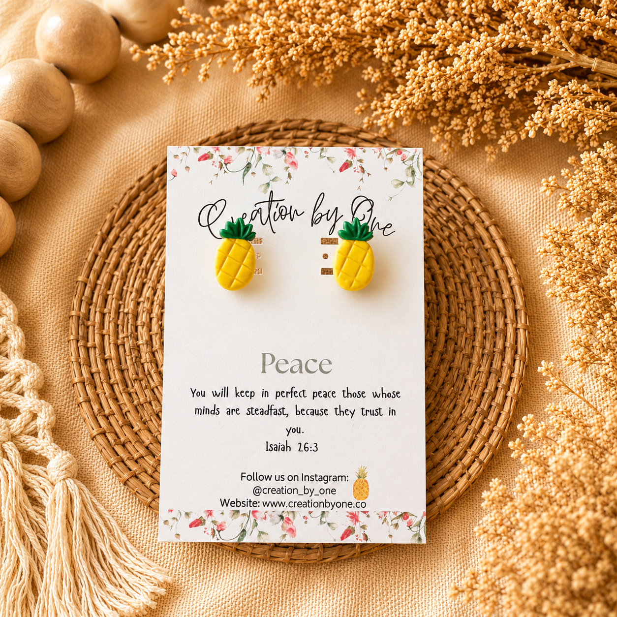 Pineapple earrings on a 'Creation by One' branded card with decorative elements on a beige background.