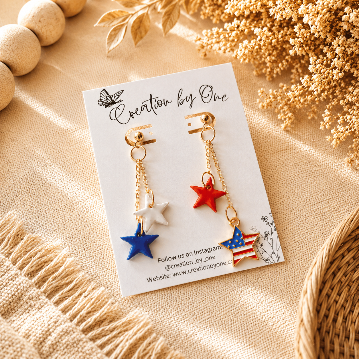 Star-shaped earrings on a branded card with decorative elements on a beige surface