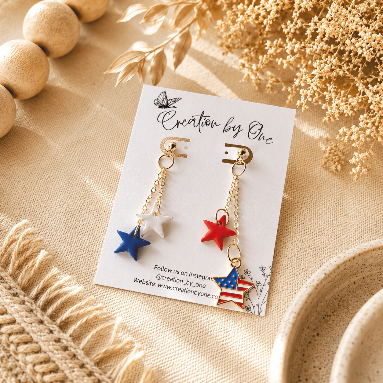 Star-shaped earrings on a 'Creation by One' branded card with decorative elements.