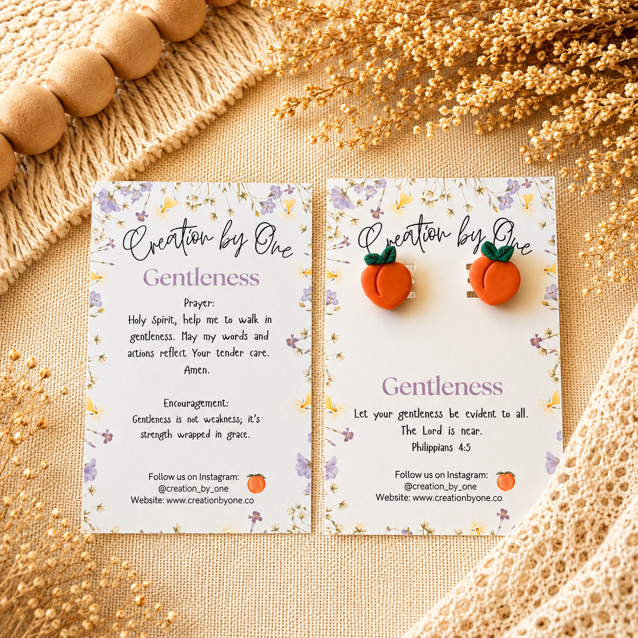 Orange earrings on a card with 'Gentleness' theme and decorative elements on a textured surface.