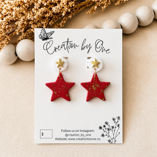 Red star-shaped earrings on a 'Creation by One' branded card with decorative elements.