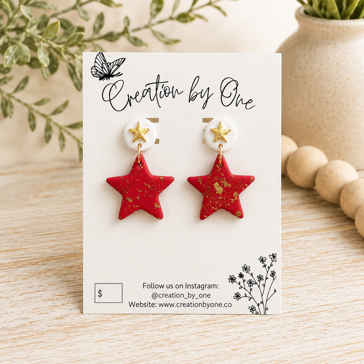 Red star-shaped earrings on a branded card with decorative elements.
