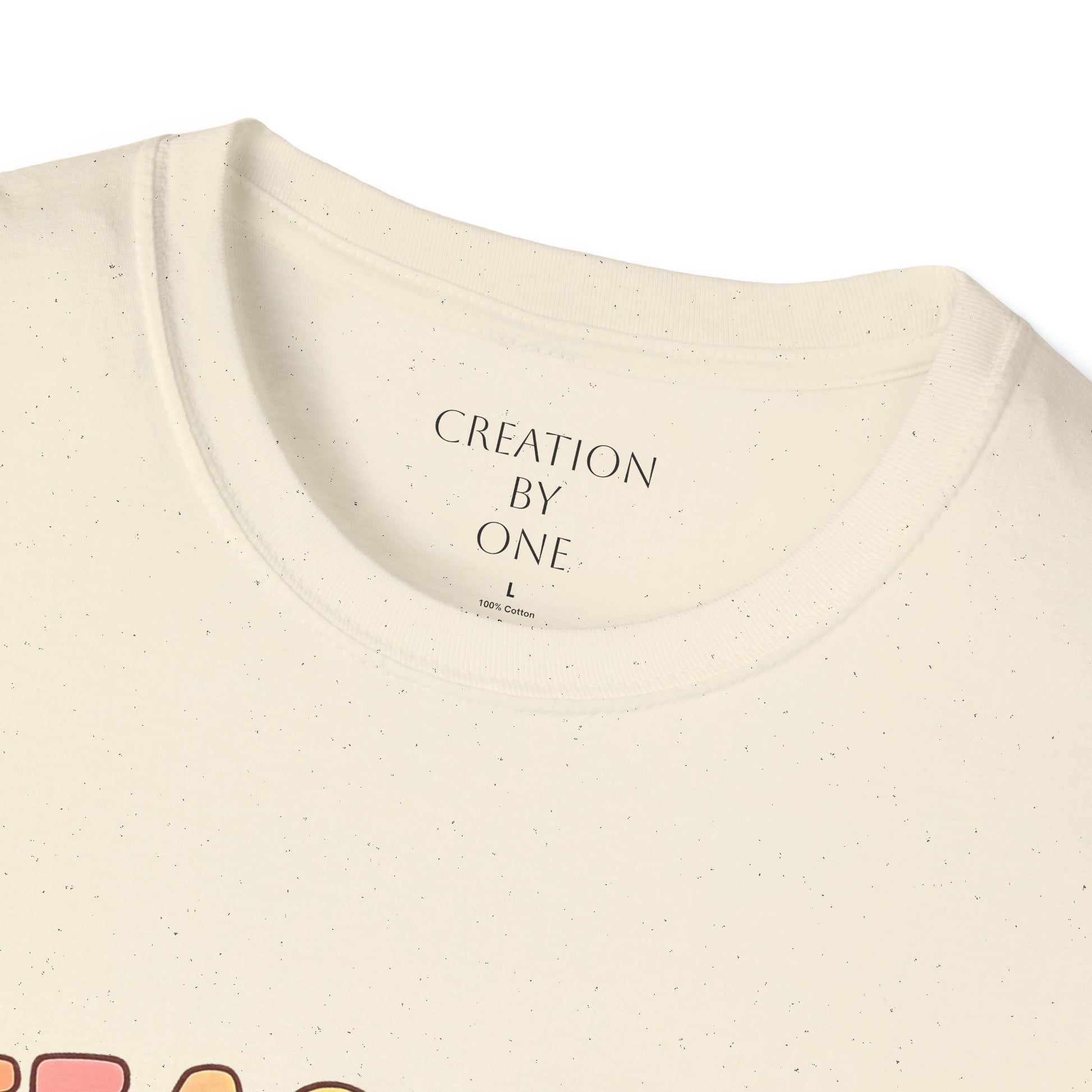 Close-up of a beige t-shirt with 'Creation by One' text on a white background