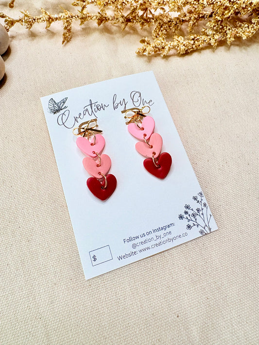 Triple heart bow earrings with light pink soft pink and red hearts and 14K gold plated stud bows by Creation by One