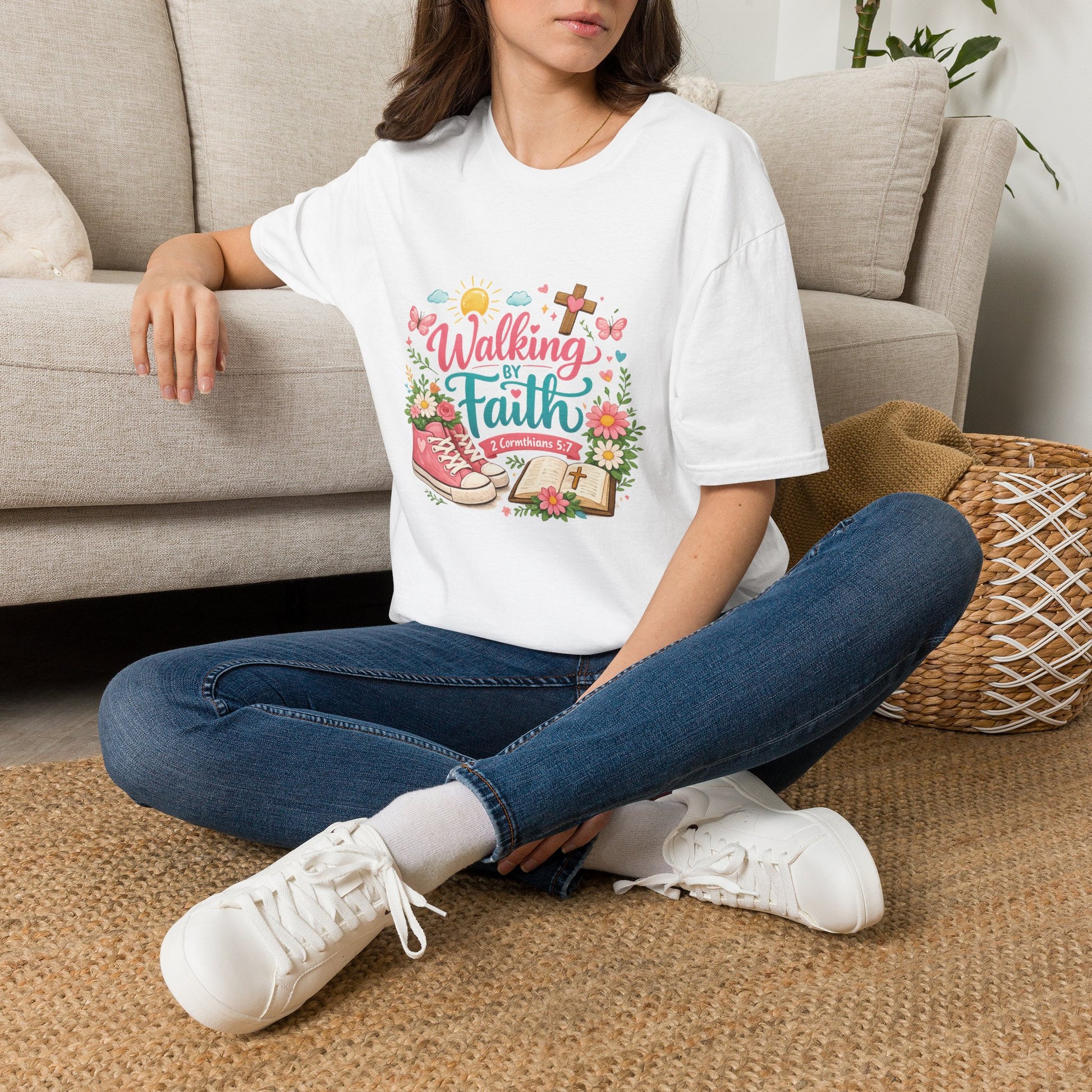 Person wearing a white t-shirt with a printed design sitting on a carpeted floor.