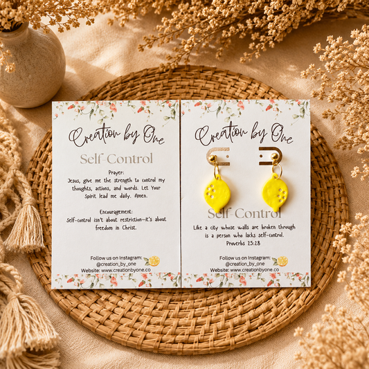 Yellow earrings on a branded card with decorative elements on a textured surface